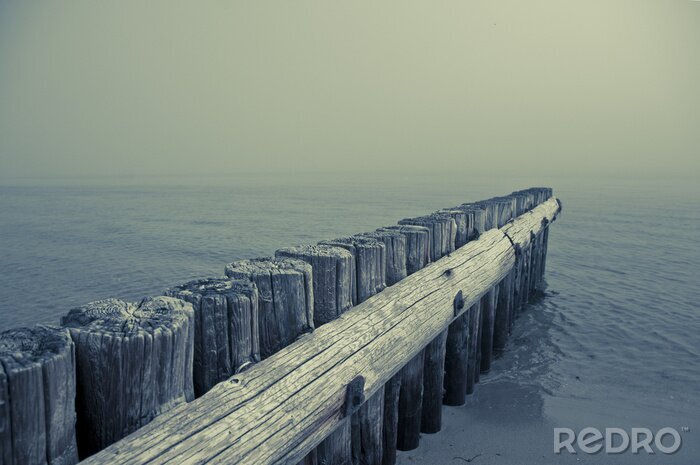 Poster Houten golfbreker bij de zee