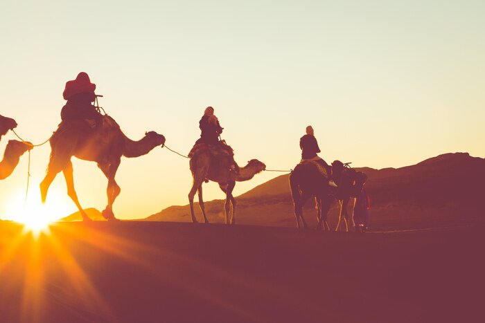 Poster Kameelcaravan met mensen die door de zandduinen gaan in Sahara Desert. Marokko, Afrika.