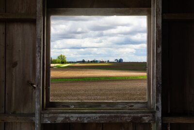 Poster Looking through the old barn window with a view of the open farmland. This morning in Malden, Illinois