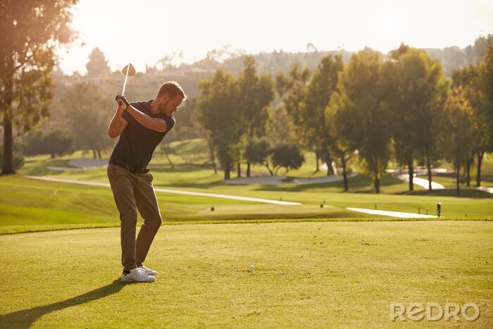 Poster Mannelijke golfer voering tee shot Aan de Golfbaan