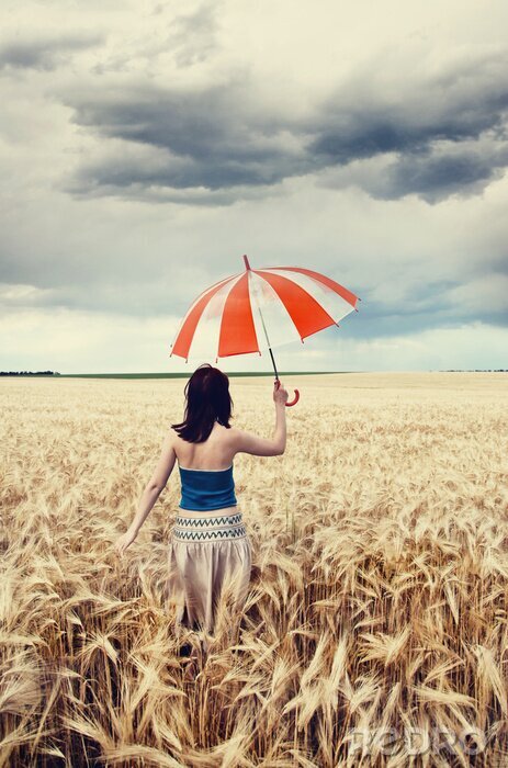 Poster Meisje met paraplu op veld.