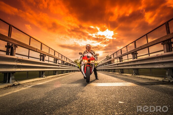 Poster Moto da strada pronta alla partenza sotto un cielo rosso al tramonto