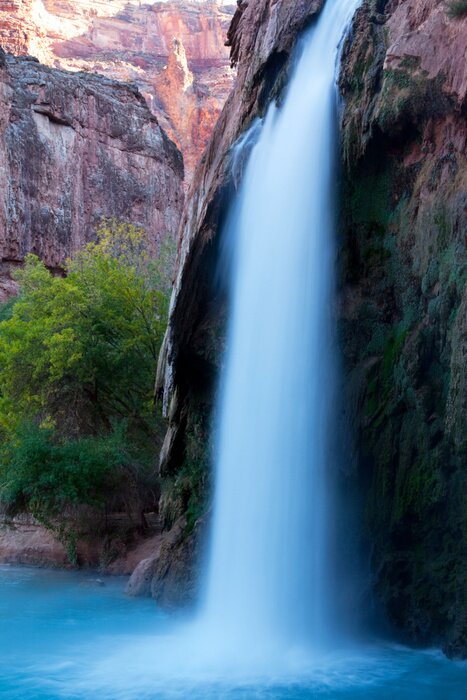 Poster Natuur en een waterval tussen de rotsen