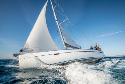 Poster One white sailing yacht floats on the sea with waves and spray. The view from the side