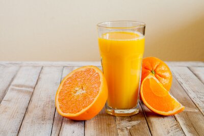 Poster Orange fruit and glass of juice on white wooden background