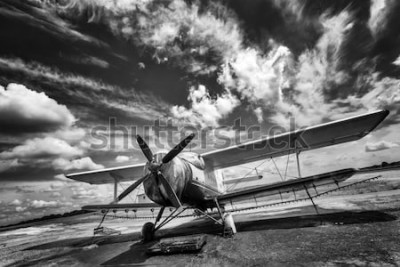 Poster Oud vliegtuig op gebied in zwart-wit