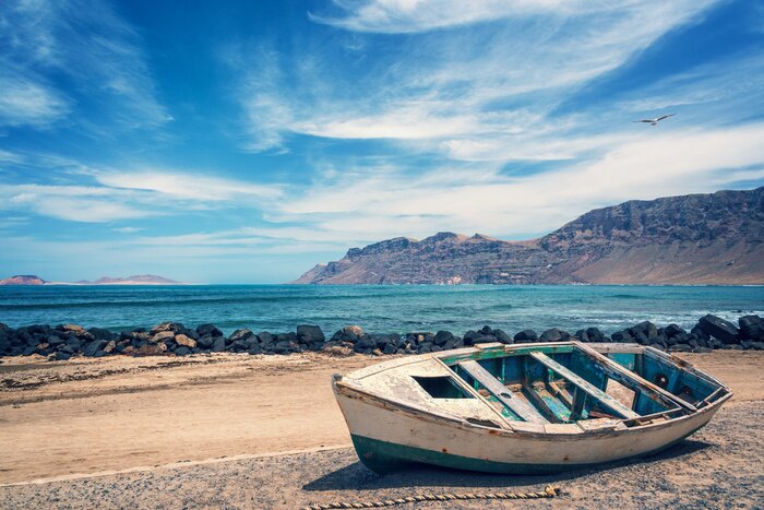 Poster Oude kleurrijke vissersboot, de Atlantische Oceaan op de achtergrond, Lanzarote, Canarische Eilanden, Spanje