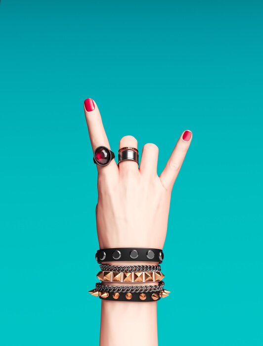 Poster Rock hand sign, female hand punk rock gesture with gold wrist bracelets and finger rings isolated, creative art protest banner, fashion hipster accessories, 3d rendering