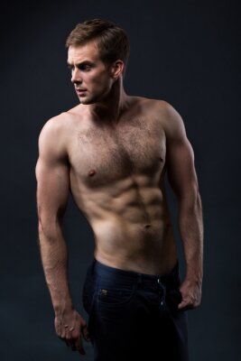 Poster Sexy jonge man met een naakte torso op een donkere achtergrond