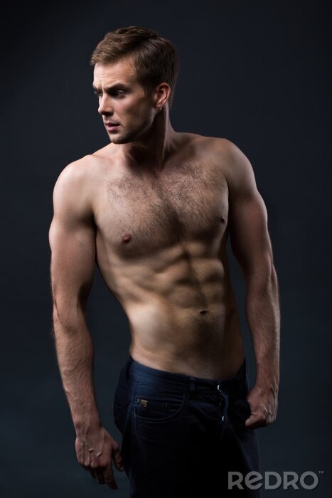 Poster Sexy jonge man met een naakte torso op een donkere achtergrond