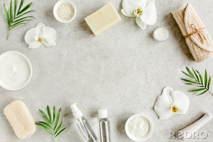 Poster Spa skincare concept. Natural/Organic spa cosmetics products, sea salt and tropic palm leaves on gray marble table from above. Spa background with a space for a text, flat lay, top view.