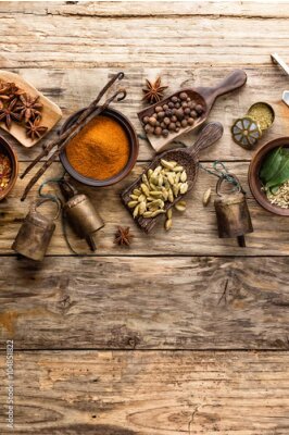 Poster Specerijen en decoratieve belletjes uitgestald op een houten aanrecht.