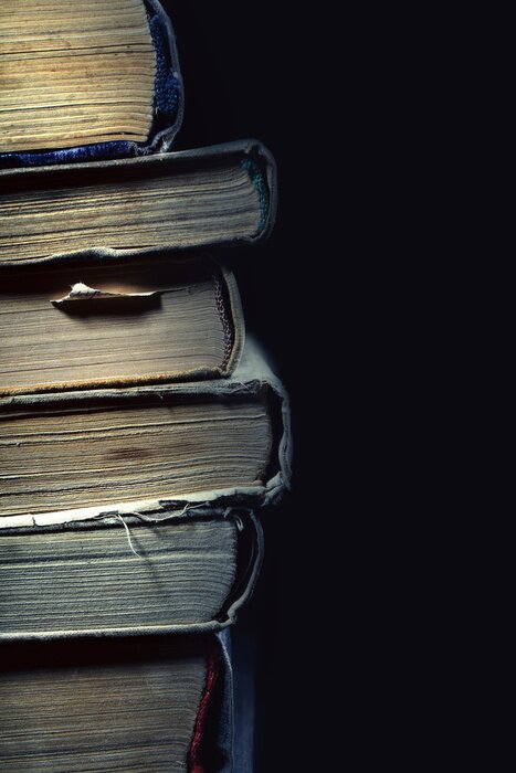 Poster Stack of old dusty shabby books on black background