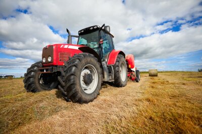 Fotobehang Trekker verzamelen hooiberg in het veld