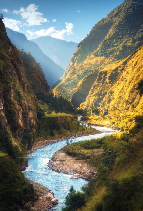 Poster Verbazend landschap met hoge Himalayan-bergen, mooie buigende rivier, groen bos, blauwe hemel met wolken en geel zonlicht in de herfst in Nepal. Bergdal. Reis in de Himalaya. Natuur