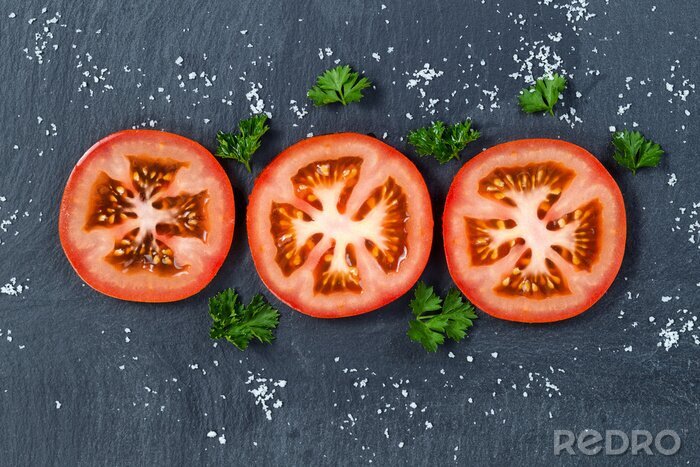 Poster Vers gesneden tomaat op een zwarte leisteen achtergrond
