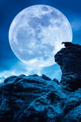 Volle maan tegen de achtergrond van de blauwe hemel