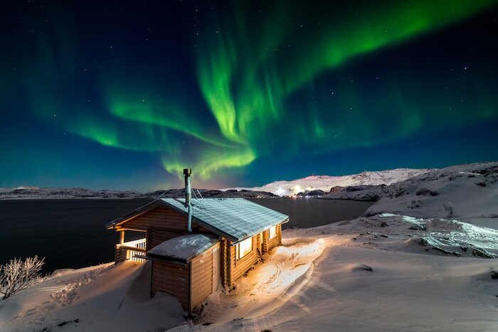 Poster Wooden cottage on the background of the Northern Lights at night.