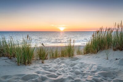 Fotobehang Zonsondergang over de zee en een zandstrand