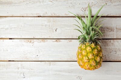 Sticker Ananas liggend op een houten tafel