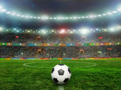 Sticker Een bal op de grasmat van een groot verlicht stadion