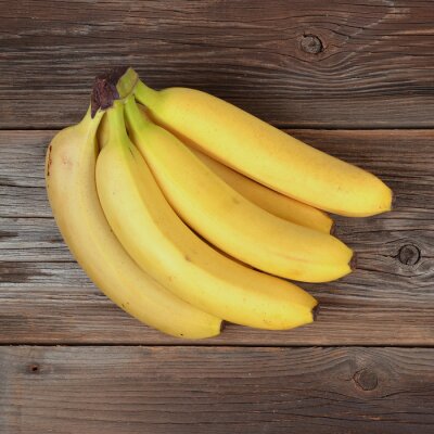 Sticker Een tros bananen op een houten ondergrond