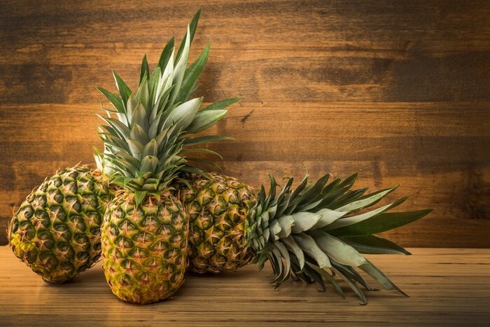 Sticker Exotische ananas op een houten tafelblad