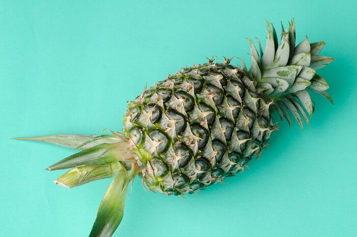Sticker Foto van een ananas op een blauwe achtergrond