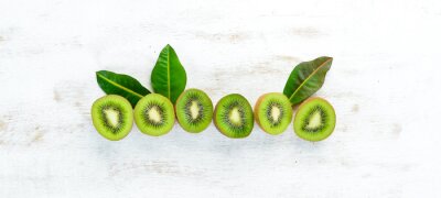 Sticker Fresh kiwi on a white wooden table. Rustic style. Fruits. Top view. Free space for text.
