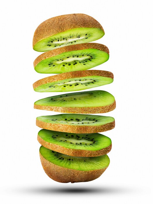 Sticker Fresh sliced kiwi fruit flying in the air isolated on white.