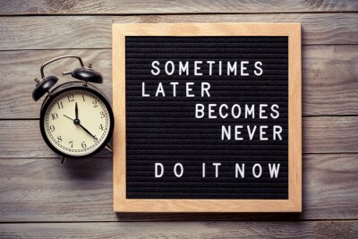 Sticker Inspirational motivational quote Sometimes later becomes never. Do it now words on a letter board on wooden background near vintage alarm clock. Success and motivation concept.