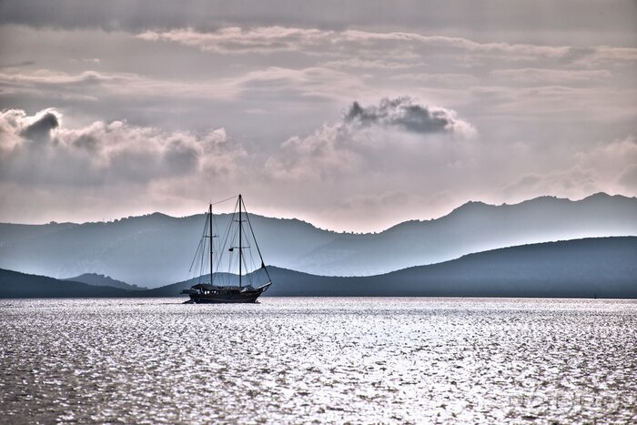 Sticker Landschap met een zeilboot in donkere kleuren
