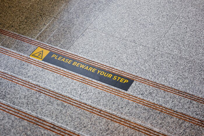 Sticker Let op uw stapsticker op gepolijste stenen vloer van dichtbij.