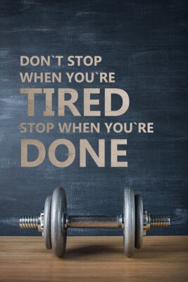 Sticker metal barbell op donkere grijze achtergrond en motivatie tekst