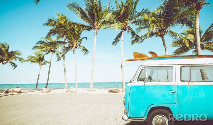 Sticker oldtimer geparkeerd op het tropische strand (aan zee) met een surfplank op het dak - recreatieve reis in de zomer. retro kleureffect