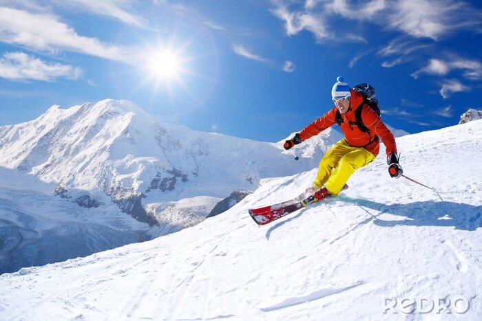 Sticker Skier ski afdaling in de hoge bergen tegen de blauwe hemel