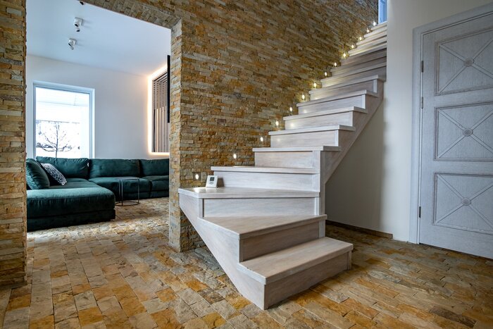Sticker Stylish wooden contemporary staircase inside loft house interior. Modern hallway with decorative limestone brick walls and white oak stairs.