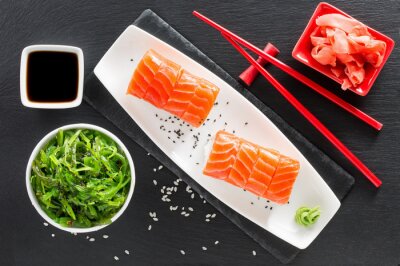 Sticker sushi en groene zeewiersalade op een lei tafel